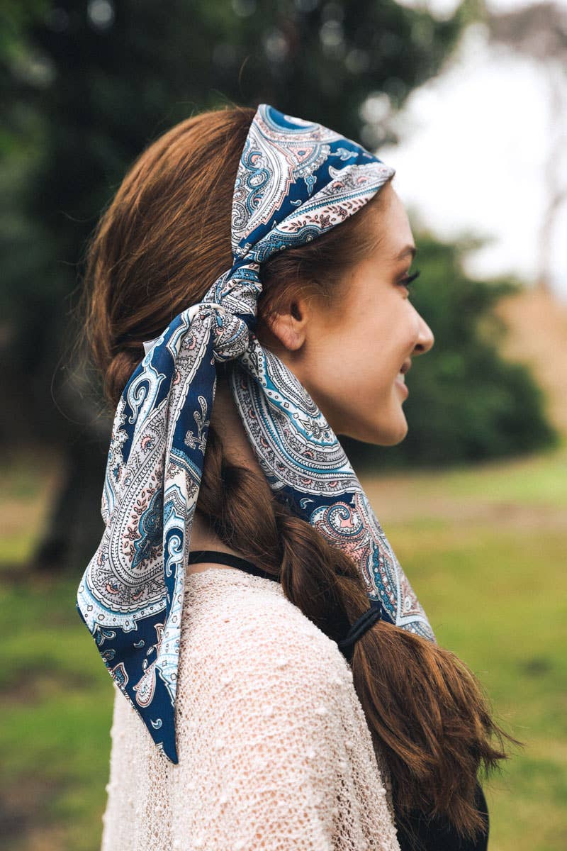 Woman in a blue paisley headscarf, profile view outdoors