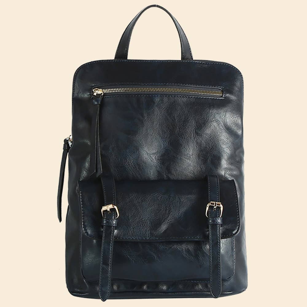 Black leather backpack with front zipper and buckle pocket on a beige background.