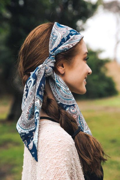 Woman in a blue paisley headscarf, profile view outdoors