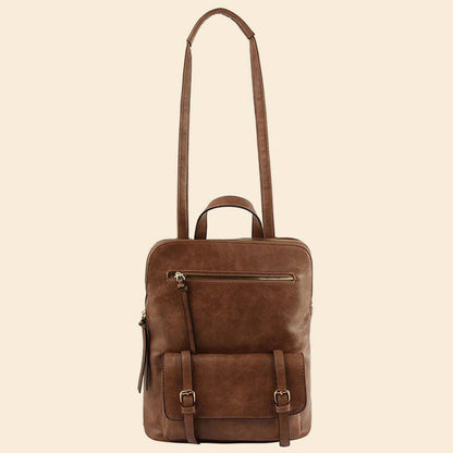 Brown leather backpack with long adjustable crossbody strap displayed on a beige background.
