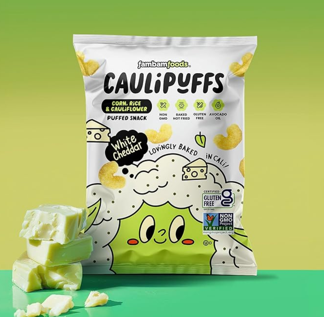 Bag of Caulipuffs White Cheddar puffed snack with cheese cubes on a green background.