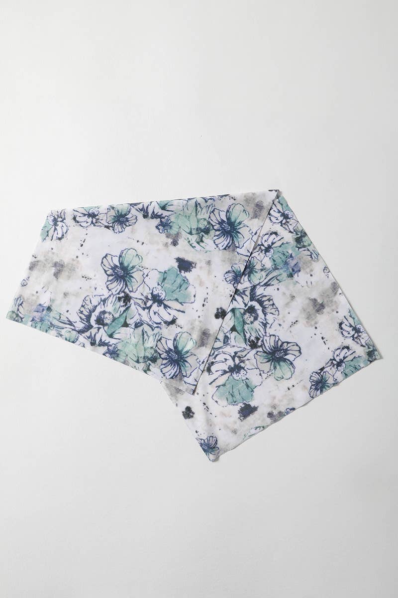 White scarf with blue and green floral pattern on a white background