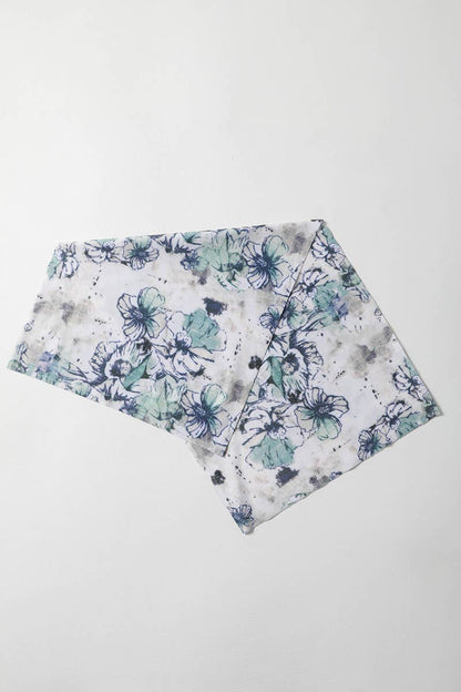 White scarf with blue and green floral pattern on a white background