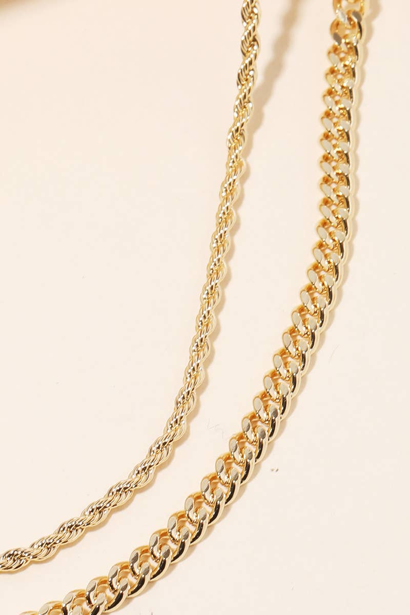 Gold necklace, two layers styled on a beige background