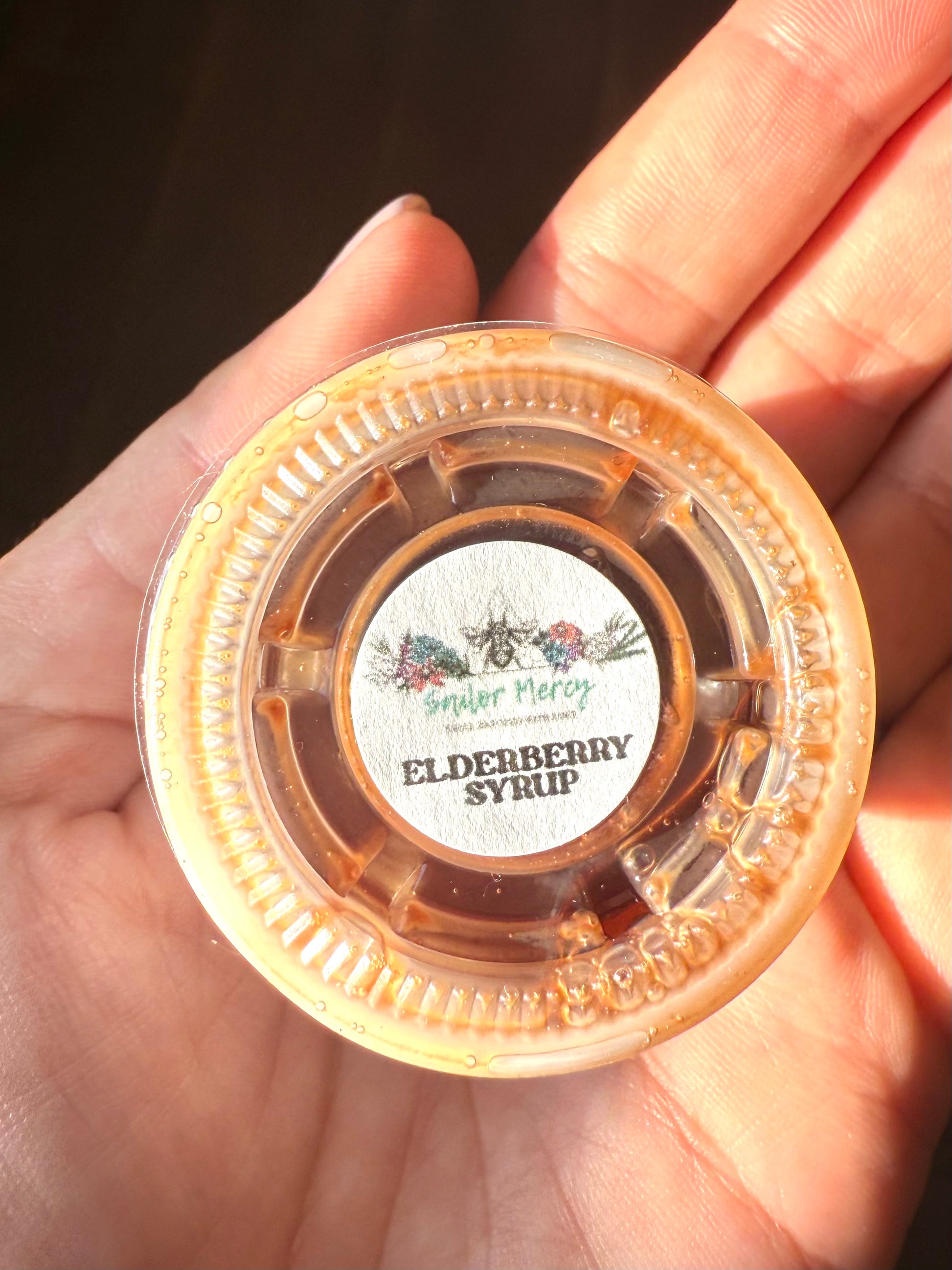 Sailor Mercy Elderberry Syrup sample container with branded label, small-batch wellness syrup made with organic ingredients for natural immune support.