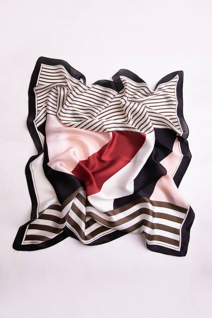Flat lay of black, white, and red striped scarf on white background