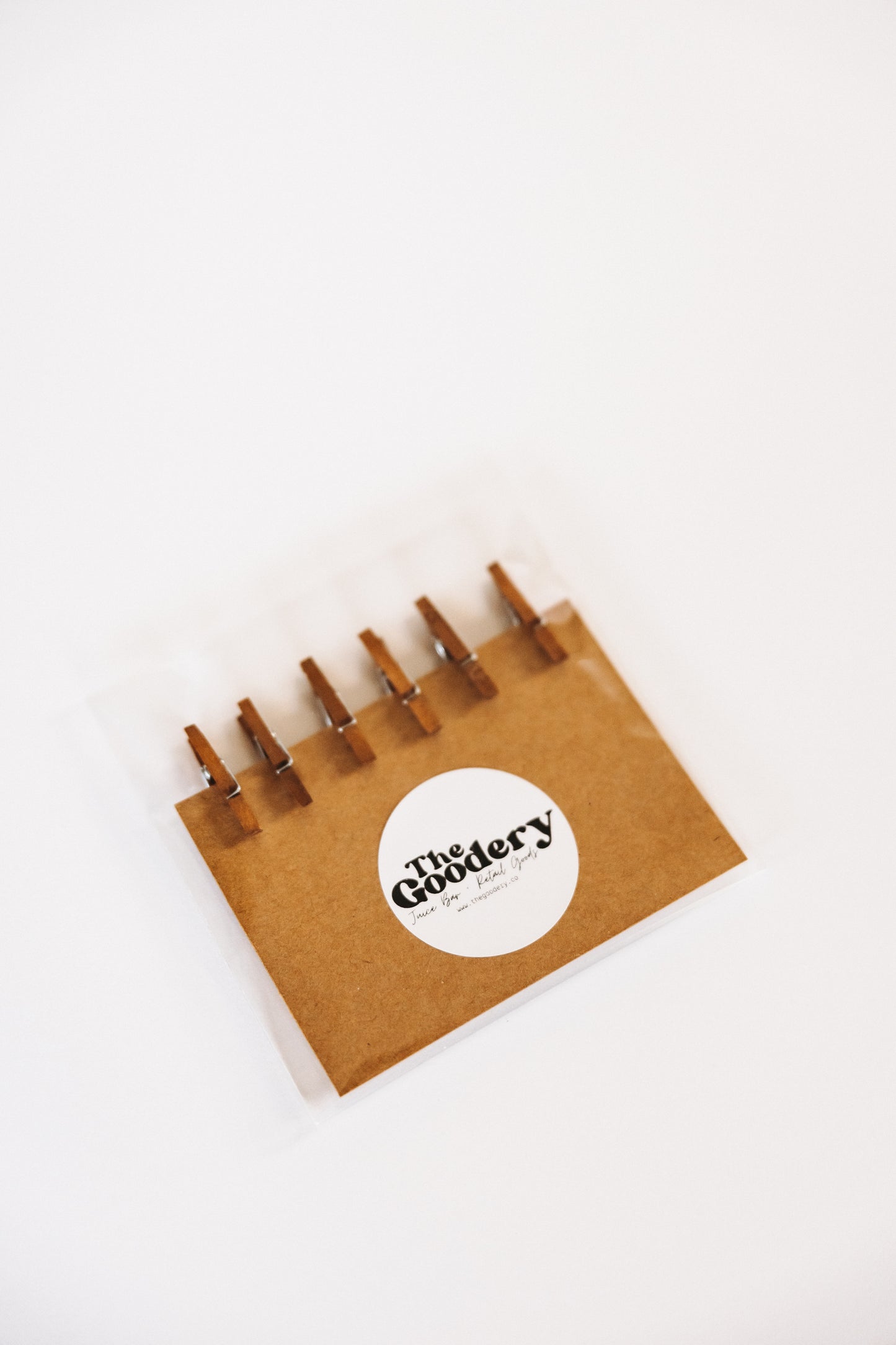 The Goodery set of six garnish clips packaged on a brown card with circular clips for cocktails and beverages.