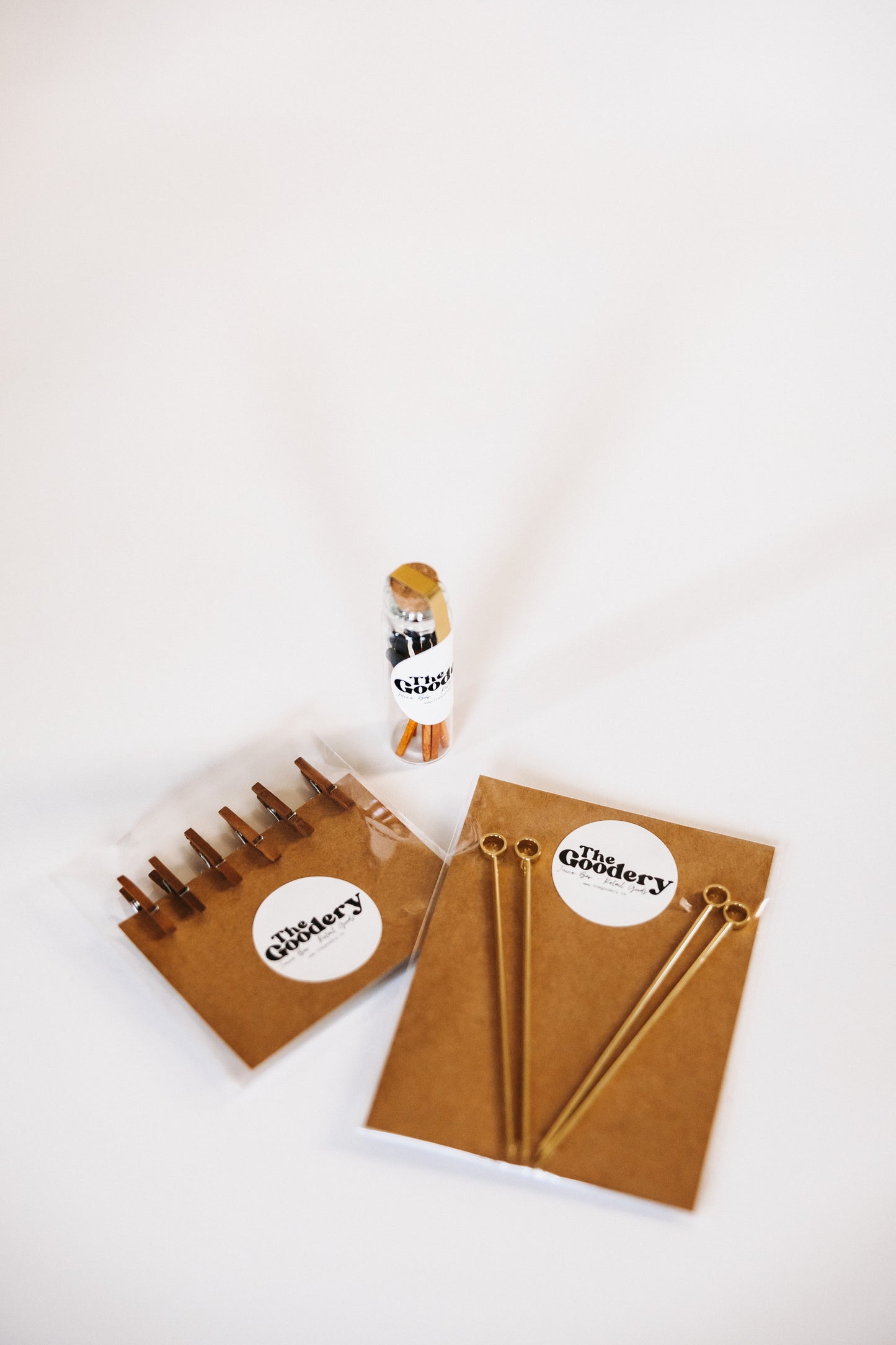 The Goodery garnish kit bundle including gold cocktail picks, garnish clips, and branded packaging on a white background.