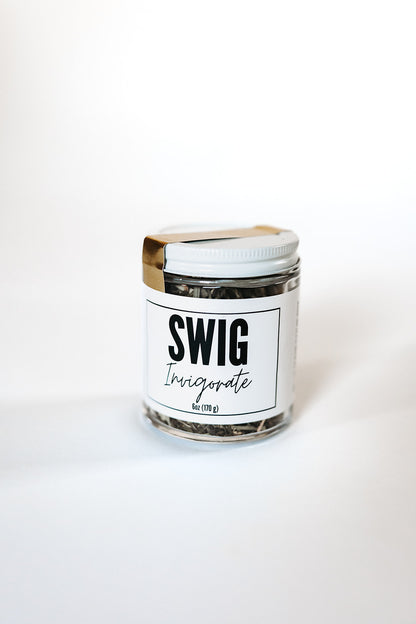 SWIG Invigorate loose leaf tea in a glass jar with white lid, labeled and displayed against a white backdrop.