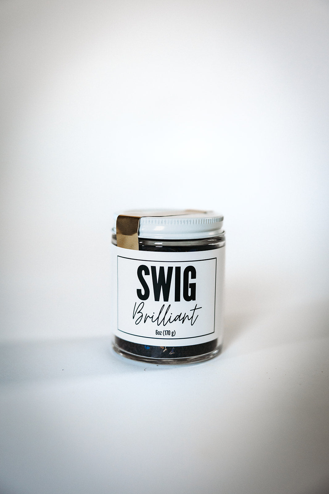 Swig Tea Blend Brilliant loose leaf tea in glass jar with white lid, displayed on white background.