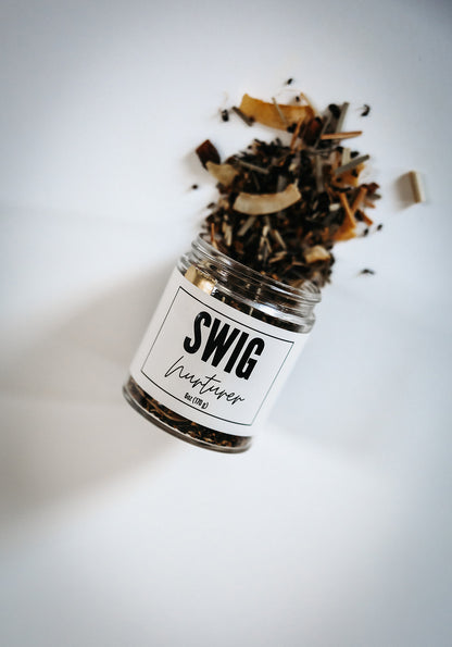 Swig Tea Blend Nurturer herbal loose leaf tea spilling from glass jar with white lid on white background.