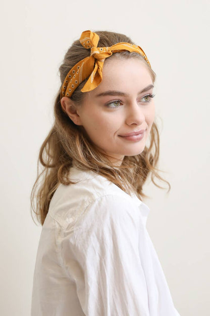 Woman with yellow patterned headband styled with bow
